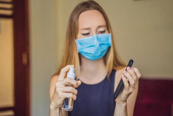 消毒电话女人医疗面具持有电话喷雾消毒剂手保护电子设备冠状病毒传输