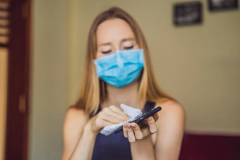 消毒电话女人医疗面具持有电话喷雾消毒剂手保护电子设备冠状病毒传输