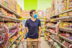 警觉男人。穿医疗面具冠状病毒杂货店购物超市商店健康安全流感大流行概念年轻的女人穿保护面具储备食物