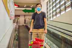 警觉男人。穿医疗面具冠状病毒杂货店购物超市商店健康安全流感大流行概念年轻的女人穿保护面具储备食物