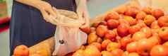 女人选择西红柿超市塑料袋可重用的袋购买蔬菜浪费概念横幅长格式