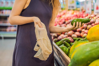 女人选择鳄梨超市塑料袋可重用的袋购买蔬菜浪费概念