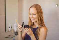 年轻的女人刷牙牙齿黑色的牙粘贴活跃的木炭黑色的牙刷浴室