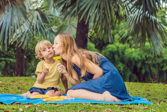 冠状病毒检疫削弱了面具公共的地方妈妈儿子野餐公园吃健康的水果芒果菠萝瓜孩子们吃健康的食物