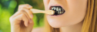年轻的女人刷牙齿激活木炭粉刷牙<strong>美白</strong>牙齿竹子生态刷横幅长格式