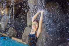 年轻的快乐的女人水流池一天水疗中心热弹簧