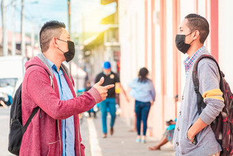年轻的人面具谈话在户外朋友脸面具谈话概念谈话社会距离