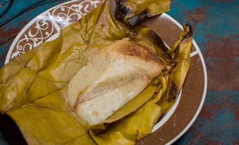 塞玉米粉蒸肉服务木表格塞玉米粉蒸肉香蕉叶服务木表格典型的尼加拉瓜食物