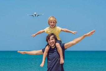 冠状病毒检疫削弱了面具旅行父亲儿子有趣的海滩看着陆飞机旅行飞机孩子们概念