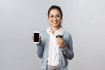办公室生活方式业务人概念年轻的热情的女老师导师推荐智能手机应用程序研究检疫喝咖啡微笑显示移动电话