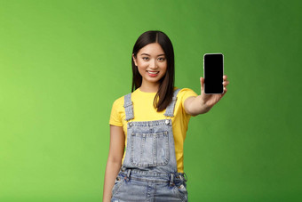 自信的有吸引力的亚洲浅黑肤色的女人显示智能手机屏幕介绍电话appllication<strong>打分</strong>数手机游戏微笑很高兴给建议遵循博客