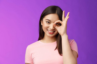 特写镜头温柔的愚蠢的友好的亚洲女人保持积极的给许可显示标志很高兴满意好质量接受条款很高兴产品站紫色的背景