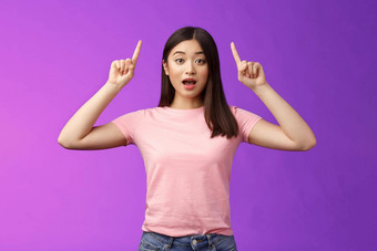兴奋可爱的惊讶亚洲女孩粉红色的t恤告诉太棒了<strong>新闻</strong>指出提高了手指前广告开放口惊讶激动站<strong>蓝色</strong>的背景