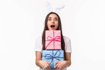 庆祝活动假期礼物概念肖像逗乐年轻的美丽的女人兔子耳朵开放口兴奋持有包礼物接收太棒了礼物白色背景