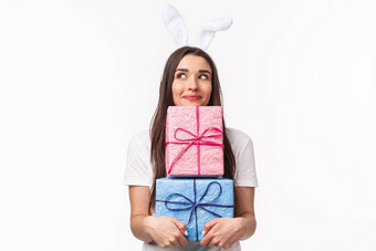 庆祝活动假期礼物概念肖像愚蠢的可爱的可爱的年轻的女孩兔子耳朵持有礼物做白日梦微笑给礼物白色背景