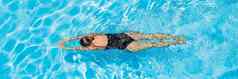 女人黑色的泳衣游泳蓝色的水池横幅长格式