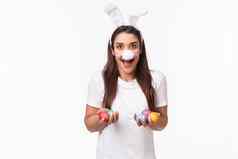 肖像兴奋快乐无忧无虑的年轻的女人支出假期家庭穿有趣的兔子耳朵鼻子持有彩色的鸡蛋绘画孩子们复活节一天白色背景
