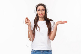 技术生活方式音乐概念肖像尴尬的沮丧年轻的悲观的女孩耳机持有线耸心烦意乱耳机打破了买无线耳塞