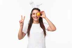 肖像和平快乐的年轻的可爱的女白色t恤肖文特和平标志持有彩色的蛋眼睛微笑快乐享受传统的假期庆祝活动复活节一天