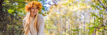 在户外生活方式关闭肖像迷人的金发女郎年轻的女人穿花环秋天叶子微笑走秋天公园穿时尚的针织<strong>套衫</strong>花环枫木叶子横幅长格式