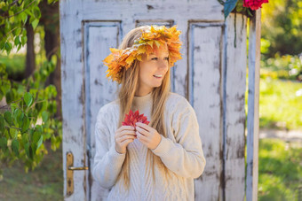 在户外生活方式关闭肖像迷人的金发女郎年轻的女人穿花环秋天叶子穿时尚的针织套衫花环枫木叶子