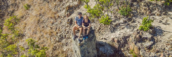 年轻的男人。女人当地的旅游坐在岩石享受视图城市当地的旅游概念旅游科维德横幅长格式