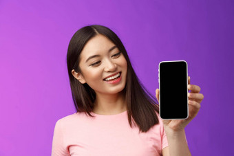 很高兴快乐的好看的年轻的亚洲女人微笑满意持有智能<strong>手机</strong>显示电话屏幕电话显示很高兴介绍<strong>应用</strong>程序现在<strong>应用</strong>程序紫色的背景
