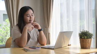 快乐年轻的女人电脑移动PC冲浪互联网阅读新闻购物在线首页