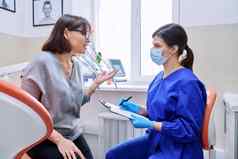 牙科办公室访问女病人会说话的医生牙医使笔记
