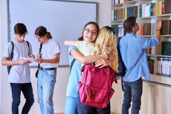 学生女孩拥抱会议集团青少年学校图书馆