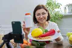 女人记录视频流健康的吃维生素营养补充