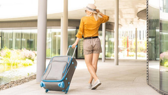 旅行者手提箱女人携带手提箱旅行位置假期旅行镜头耀斑技术旅行假期概念