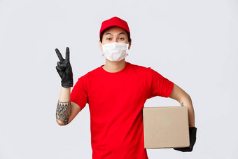 概念交付航空公司冠状病毒流感大流行可爱的快递红色的帽t恤医疗面具手套显示和平标志持有盒子交付客户端航运在线订单