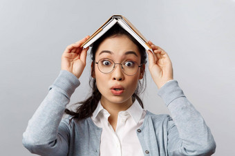 教育大学人概念特写镜头肖像wondred逗乐亚洲女眼镜持有规划师笔记本书头意识到有趣的灰色背景