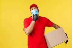 表达交付流感大流行科维德安全航运在线购物概念英俊的快递红色的统一的医疗面具持有包触摸下巴时髦的黄色的背景