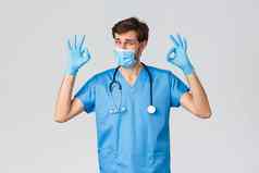 医疗保健工人冠状病毒检疫运动流感大流行概念很高兴英俊的医生外科医生完成操作显示标志穿医疗面具手套采取护理病人