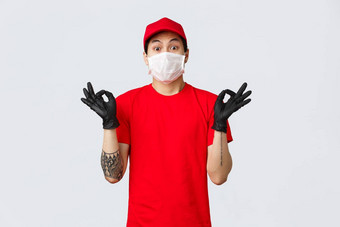 担心年轻的亚洲交付男人。平静紧张客户端显示Zen手势穿医疗面具保护手套公司统一的快递使标志确保质量
