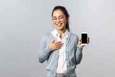技术在线移动生活方式概念微笑厚颜无耻的亚洲女孩吹牛互联网社会媒体配置文件显示图片假期智能手机显示笑自负的