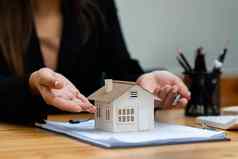 女人持有检查房子模型真正的房地产房子评估检查保险概念