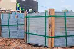 工业建筑水泥按下材料混凝土块水泥砖完成了产品托盘简洁堆放木框架建设网站房子绳子磁带包装开放空气天空