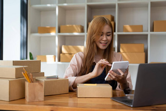 年轻的女人小业务老板在线购物首页确认订单客户移动手机准备包产品背景锻造企业家自由生活风格概念