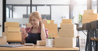 快乐年轻的亚洲女人企业家微笑销售成功检查订单在线购物商店智能手机首页办公室概念商人业务在线电子商务