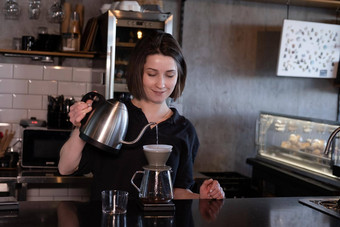 迷人的浅黑肤色的女人女人咖啡师使过滤器咖啡咖啡商店酝酿咖啡咖啡馆