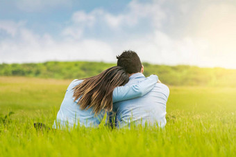 浪漫的夫妇坐着草拥抱回来后视图夫妇爱拥抱草夫妇爱坐着草拥抱回来