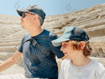 年轻的父亲爸爸学校男孩孩子儿子游客参观古老的古董竞技场圆形露天剧场废墟热夏天一天