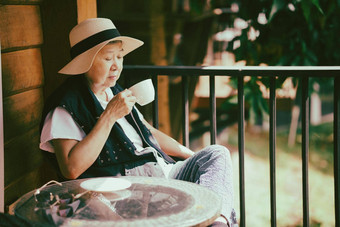 上了年纪的高级老女人喝热咖啡阳台