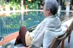 上了年纪的高级老女人休息放松在游泳池边游泳池酒店