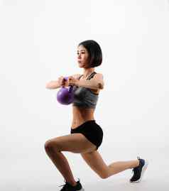 运动女人运动服装壶铃健身锻炼白色背景健康的体育运动生活方式