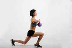 运动女人运动服装壶铃健身锻炼白色背景健康的体育运动生活方式