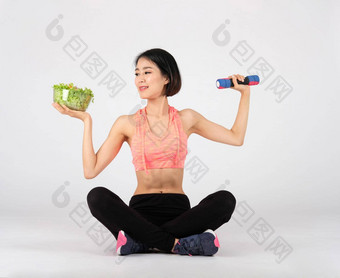 <strong>运动健身</strong>女人运动服装蔬菜沙拉哑铃白色背景健康的体育运动